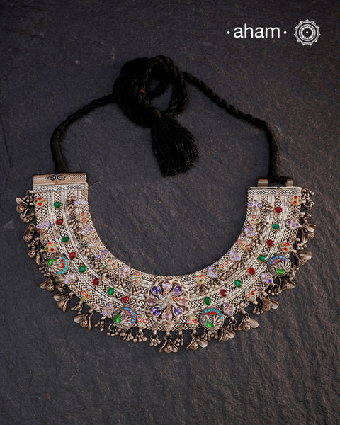 This Tribal Silver Anklet has been transformed into a stunning Neckpiece featuring vibrant glass stones. Handcrafted with care, this vintage piece adds a touch of color and heritage to any outfit. Perfect for those who appreciate unique and one-of-a-kind jewellery.