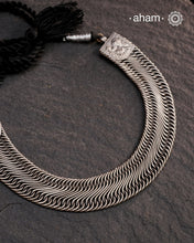 This Tribal Flat Silver Neckpiece features intricate wire weaving that contours elegantly around the neck. Crafted from high-quality silver, its timeless design complements both Indian traditional attire and contemporary western outfits, making it a versatile addition to any jewellery collection.