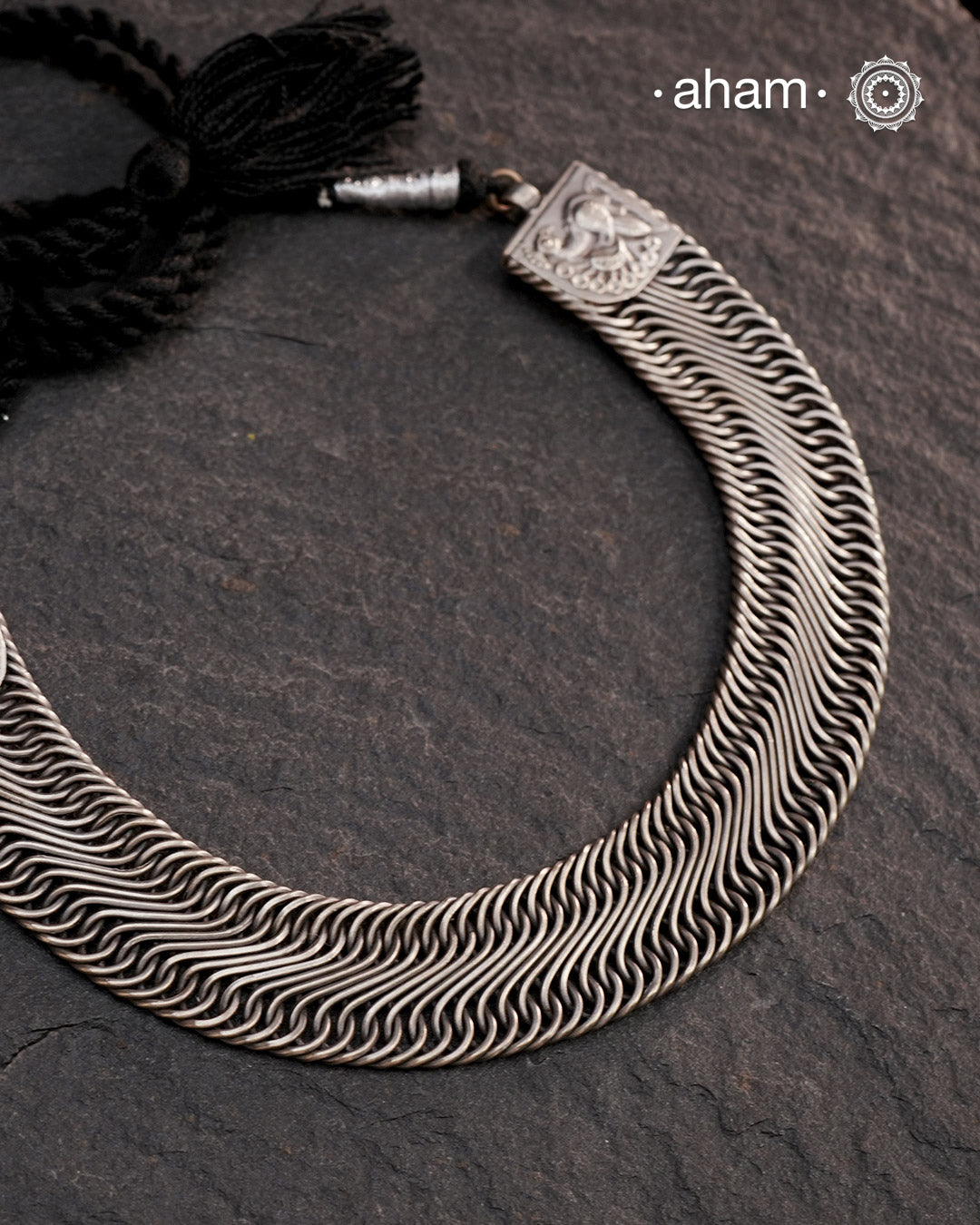 This Tribal Flat Silver Neckpiece features intricate wire weaving that contours elegantly around the neck. Crafted from high-quality silver, its timeless design complements both Indian traditional attire and contemporary western outfits, making it a versatile addition to any jewellery collection.