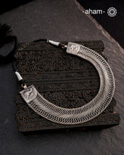 This Tribal Flat Silver Neckpiece features intricate wire weaving that contours elegantly around the neck. Crafted from high-quality silver, its timeless design complements both Indian traditional attire and contemporary western outfits, making it a versatile addition to any jewellery collection.