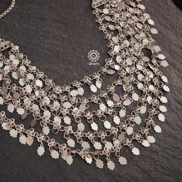 This stunning Tribal Silver Neckpiece features a multi-line design accented with delicate hanging leaves. Crafted for a lightweight yet bold look, it will add a touch of elegance to any outfit. Elevate your style with this unique piece, perfect for making a statement.