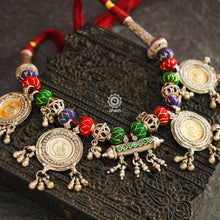 This exquisite tribal neckpiece features a unique arrangement of threaded pieces, all artfully crafted from silver.