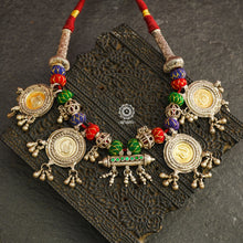 This exquisite tribal neckpiece features a unique arrangement of threaded pieces, all artfully crafted from silver.