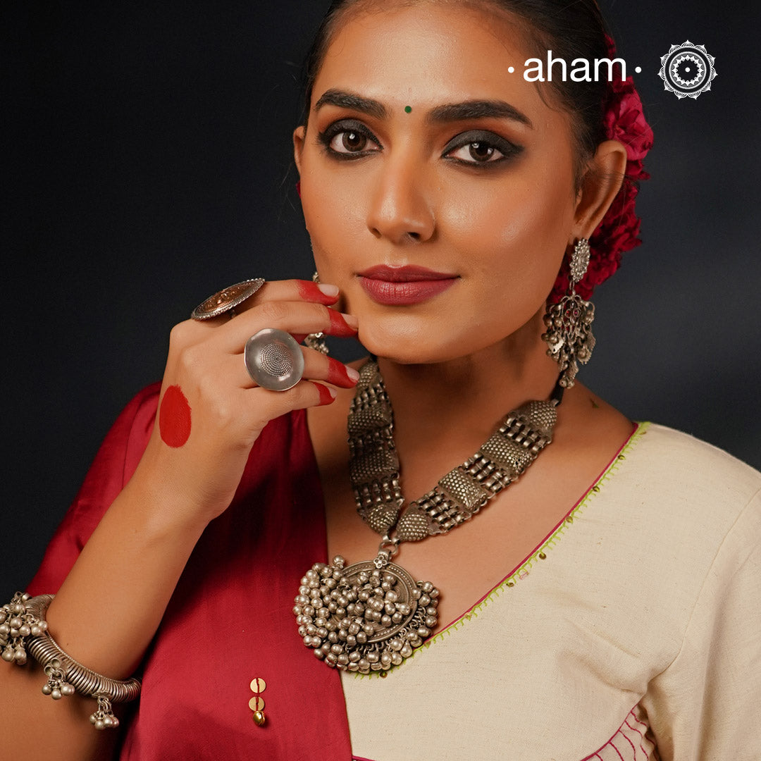 This Tribal Silver Neckpiece features a stunning vintage Ghungroo pendant and delicate silver bands. A perfect accessory for celebrating Navratri, this necklace adds a touch of traditional elegance to any outfit. Embrace cultural heritage with this unique piece.