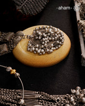 This Tribal Silver Neckpiece features a stunning vintage Ghungroo pendant and delicate silver bands. A perfect accessory for celebrating Navratri, this necklace adds a touch of traditional elegance to any outfit. Embrace cultural heritage with this unique piece.