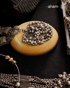 This Tribal Silver Neckpiece features a stunning vintage Ghungroo pendant and delicate silver bands. A perfect accessory for celebrating Navratri, this necklace adds a touch of traditional elegance to any outfit. Embrace cultural heritage with this unique piece.