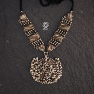 This Tribal Silver Neckpiece features a stunning vintage Ghungroo pendant and delicate silver bands. A perfect accessory for celebrating Navratri, this necklace adds a touch of traditional elegance to any outfit. Embrace cultural heritage with this unique piece.