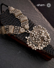This Tribal Silver Neckpiece features a stunning vintage Ghungroo pendant and delicate silver bands. A perfect accessory for celebrating Navratri, this necklace adds a touch of traditional elegance to any outfit. Embrace cultural heritage with this unique piece.