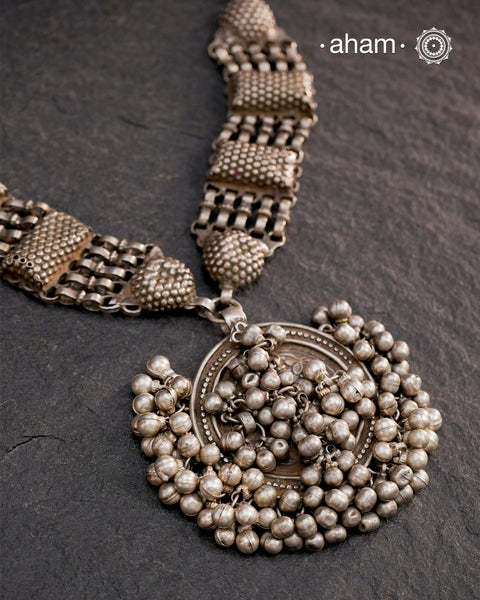 This Tribal Silver Neckpiece features a stunning vintage Ghungroo pendant and delicate silver bands. A perfect accessory for celebrating Navratri, this necklace adds a touch of traditional elegance to any outfit. Embrace cultural heritage with this unique piece.