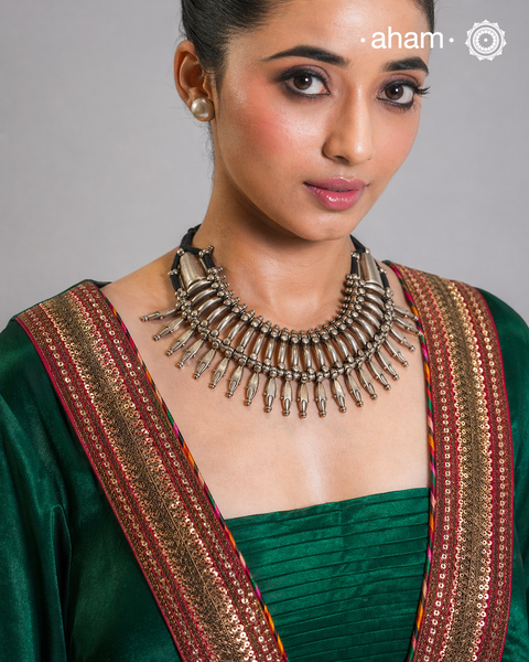 This tribal silver neckpiece is a re-creation of a popular design from the Himalayan foothills. Crafted in silver, it offers a unique and striking accessory that showcases traditional craftsmanship. Elevate your style with this beautiful piece.