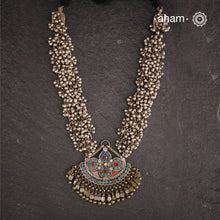 This Tribal Silver Neckpiece features a stunning pendant from Afghanistan, complemented by tribal ear/head chains and multiple ghungroos for added drama. A true treasure for any jewellery lover.