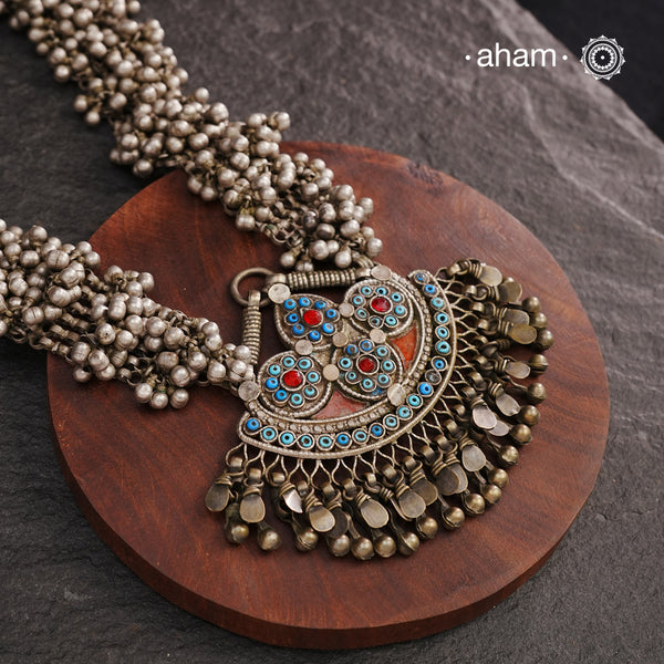 This Tribal Silver Neckpiece features a stunning pendant from Afghanistan, complemented by tribal ear/head chains and multiple ghungroos for added drama. A true treasure for any jewellery lover.