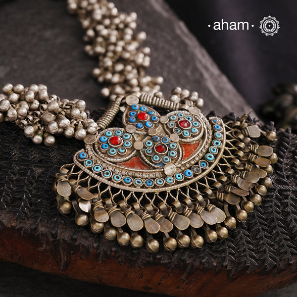 This Tribal Silver Neckpiece features a stunning pendant from Afghanistan, complemented by tribal ear/head chains and multiple ghungroos for added drama. A true treasure for any jewellery lover.