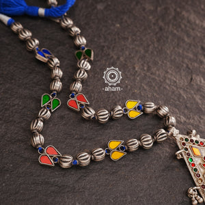 Experience the elegance and timelessness of our Tribal Silver Neckpiece. Handcrafted with a vintage silver piece, highlighted with vibrant coloured glass, and adorned with  silver beads, this necklace is a true statement of style. Complement any outfit with its unique and intricate design.