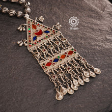 Experience the elegance and timelessness of our Tribal Silver Neckpiece. Handcrafted with a vintage silver piece, highlighted with vibrant coloured glass, and adorned with  silver beads, this necklace is a true statement of style. Complement any outfit with its unique and intricate design.