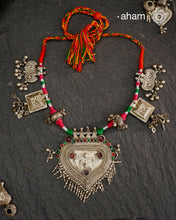 Crafted in stunning silver, this Tribal Silver Neckpiece is a one of a kind accessory that showcases a beautiful combination of vintage pieces threaded together. Its unique design is perfect for Navratri celebrations, making it a must-have addition to your jewellery collection. Elevate any outfit with its elegant, statement-making style.
