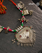 Crafted in stunning silver, this Tribal Silver Neckpiece is a one of a kind accessory that showcases a beautiful combination of vintage pieces threaded together. Its unique design is perfect for Navratri celebrations, making it a must-have addition to your jewellery collection. Elevate any outfit with its elegant, statement-making style.