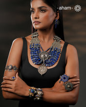 This Tribal Silver Neckpiece is a unique masterpiece designed to make a bold statement. Crafted from vintage silver pieces, it features lapiz stones. Its versatile design complements both traditional and western outfits, offering a distinctive touch to your style. Perfect for those who appreciate unique statement pieces.&nbsp;
