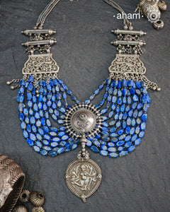 This Tribal Silver Neckpiece is a unique masterpiece designed to make a bold statement. Crafted from vintage silver pieces, it features lapiz stones. Its versatile design complements both traditional and western outfits, offering a distinctive touch to your style. Perfect for those who appreciate unique statement pieces.