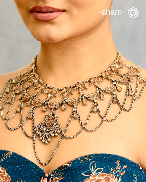 This Tribal Glass Silver Neckpiece showcases exquisite craftsmanship of traditional designs from Rajasthan and Uttar Pradesh. Set in silver with vibrant glass elements . Perfect for adding an authentic ethnic touch to your collection, this neckpiece combines artistry with timeless elegance.