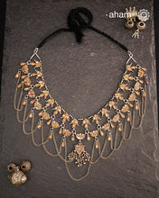 This Tribal Glass Silver Neckpiece showcases exquisite craftsmanship inspired by traditional designs from Rajasthan and Uttar Pradesh. Set in sterling silver, the vibrant glass elements highlight the rich cultural heritage of these regions. Perfect for adding an authentic ethnic touch to your collection, this neckpiece combines artistry with timeless elegance.