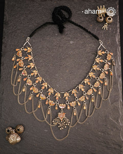 This Tribal Glass Silver Neckpiece showcases exquisite craftsmanship inspired by traditional designs from Rajasthan and Uttar Pradesh. Set in sterling silver, the vibrant glass elements highlight the rich cultural heritage of these regions. Perfect for adding an authentic ethnic touch to your collection, this neckpiece combines artistry with timeless elegance.