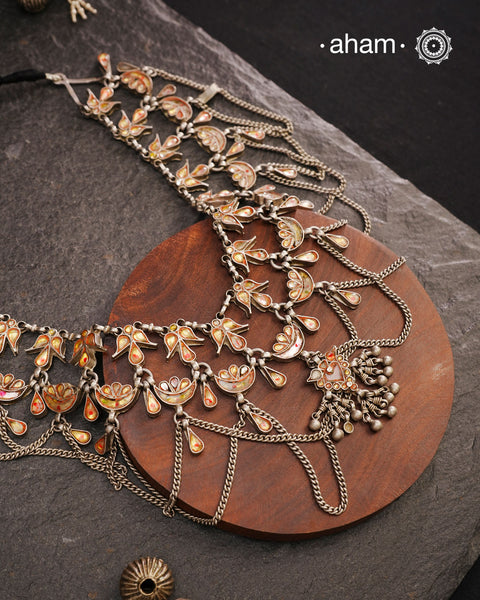 This Tribal Glass Silver Neckpiece showcases exquisite craftsmanship inspired by traditional designs from Rajasthan and Uttar Pradesh. Set in sterling silver, the vibrant glass elements highlight the rich cultural heritage of these regions. Perfect for adding an authentic ethnic touch to your collection, this neckpiece combines artistry with timeless elegance.