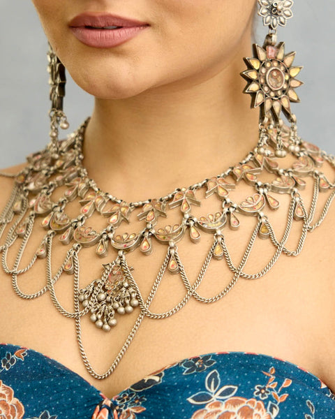 This Tribal Glass Silver Neckpiece showcases exquisite craftsmanship inspired by traditional designs from Rajasthan and Uttar Pradesh. Set in sterling silver, the vibrant glass elements highlight the rich cultural heritage of these regions. Perfect for adding an authentic ethnic touch to your collection, this neckpiece combines artistry with timeless elegance.