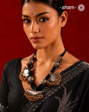 Elevate your style with this Tribal Two Tone Silver Neckpiece, featuring a captivating amulet center framed by elegant paan-shaped beads. The gold-dipped ghungroos add a stunning dual-tone contrast, making this piece truly one-of-a-kind. Perfect for those who want to make a bold cultural statement while embracing exquisite craftsmanship. Don’t miss the chance to own a unique accessory.