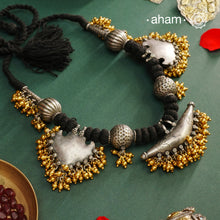 Elevate your style with this Tribal Two Tone Silver Neckpiece, featuring a captivating amulet center framed by elegant paan-shaped beads. The gold-dipped ghungroos add a stunning dual-tone contrast, making this piece truly one-of-a-kind. Perfect for those who want to make a bold cultural statement while embracing exquisite craftsmanship. Don’t miss the chance to own a unique accessory.