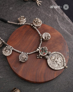 The Tribal Silver Neckpiece is an exceptional piece featuring a meticulously stamped silver pendant of Kal Bhairav. This distinctive design incorporates seven vintage kajal boxes, carefully threaded together with beads to create a harmonious blend of cultural heritage and artisanal craftsmanship. Ideal for connoisseurs of unique jewelry, this neckpiece offers both symbolic depth and aesthetic appeal.