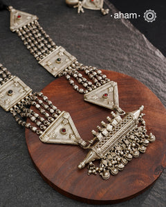 This tribal silver neckpiece features an amulet pendant and traditional side belts, reflecting the rich heritage of Rajasthan and Gujarat. Crafted entirely in silver, it offers a unique blend of cultural artistry and timeless elegance. Perfect for those who appreciate authentic, handcrafted jewellery with a meaningful story.
