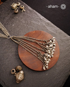 This Vintage Tribal Silver Neckpiece combines two unique tribal designs into one elegant creation. Crafted from silver, it features a simple yet striking long silhouette that enhances any outfit. The standout mango ambi beads at the bottom add a distinctive touch, showcasing expert craftsmanship and timeless style. Perfect for those who appreciate authentic vintage artistry with a refined finish.