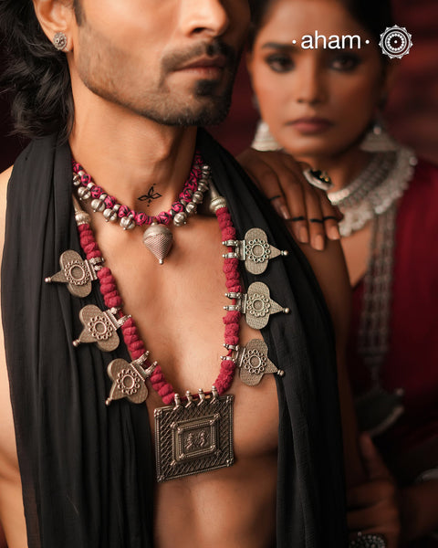 This Tribal Silver Neckpiece artfully combines vintage and contemporary elements. At its heart lies a vintage Ganesh Lakshmi pendant, surrounded by newly crafted paan-shaped beads inspired by traditional designs. Crafted in silver, the piece is elevated by rich maroon Powai accents that add a dramatic and elegant touch, making it a unique statement of timeless artistry.