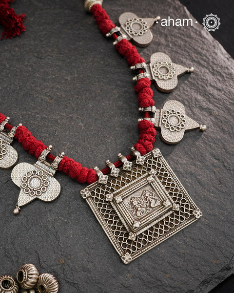 This Tribal Silver Neckpiece artfully combines vintage and contemporary elements. At its heart lies a vintage Ganesh Lakshmi pendant, surrounded by newly crafted paan-shaped beads inspired by traditional designs. Crafted in silver, the piece is elevated by rich maroon Powai accents that add a dramatic and elegant touch, making it a unique statement of timeless artistry.