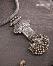 This Tribal Silver Neckpiece showcases a unique vintage buckle pendant sourced from the Rajasthan/Gujarat region, paired with a cluster of traditional ghungroos. The hand-woven silver chain adds intricate craftsmanship, making this statement piece a remarkable blend of heritage and artistry. Perfect for those who appreciate authentic, handcrafted silver jewellery with cultural significance.