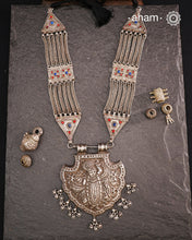 For those seeking a bold and striking accessory, the Shrenathji Tribal Silver Neckpiece is an exceptional choice. It features a large Shrinathji pendant, meticulously recreated from a vintage museum piece, complemented by side neckpiece bands characteristic of Jaisalmer craftsmanship. This piece is designed for women who appreciate distinctive, statement-making jewellery rooted in rich cultural heritage.