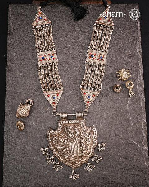 For those seeking a bold and striking accessory, the Shrenathji Tribal Silver Neckpiece is an exceptional choice. It features a large Shrinathji pendant, meticulously recreated from a vintage museum piece, complemented by side neckpiece bands characteristic of Jaisalmer craftsmanship. This piece is designed for women who appreciate distinctive, statement-making jewellery rooted in rich cultural heritage.