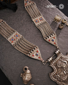 For those seeking a bold and striking accessory, the Shrenathji Tribal Silver Neckpiece is an exceptional choice. It features a large Shrinathji pendant, meticulously recreated from a vintage museum piece, complemented by side neckpiece bands characteristic of Jaisalmer craftsmanship. This piece is designed for women who appreciate distinctive, statement-making jewellery rooted in rich cultural heritage.