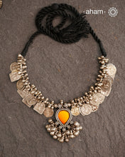 This Tribal Silver Neckpiece features a stunning glass pendant as the central piece and multiple small amulets and glass beads along with multiple ghungroos for added drama. A true treasure for any jewellery lover.