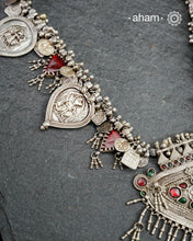 This Tribal Silver Neckpiece features a stunning pendant as the central piece and multiple small amulets and glass beads along with multiple ghungroos for added drama. A true treasure for any jewellery lover.