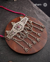 This Tribal Silver Choker features a unique design, with a silver armband transformed into a stylish choker. Adorned with beautiful chilai work and colorful stone accents, this piece adds a touch of cultural elegance to any outfit. Enhance your style with this one-of-a-kind choker.