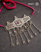 This Tribal Silver Choker features a unique design, with a silver armband transformed into a stylish choker. Adorned with beautiful chilai work and colorful stone accents, this piece adds a touch of cultural elegance to any outfit. Enhance your style with this one-of-a-kind choker.