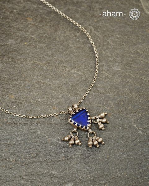 A charming piece inspired by traditional tribal adornments, this neckpiece features a vibrant blue glass pendant accented with silver ghungroos that sway gently with movement. The striking colour of the glass contrasts beautifully with the rustic silver finish, creating a look that is both distinctive and effortless.

Lightweight and easy to style, it pairs beautifully with handloom sarees, cotton kurtas, dresses, and everyday separates.