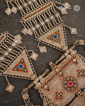 An extraordinary statement piece, this elaborate silver necklace brings together the bold geometry, vivid colour and intricate metalwork associated with the jewellery traditions of Afghanistan.