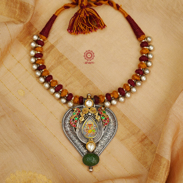 This Handpainted Ganesha Two Tone Silver Neckpiece features a beautifully crafted miniature hand painted ganesha with gold kundan highlights and two elegant peacocks. Handmade with intricate details, this neckpiece is a perfect accessory for any outfit and showcases a blend of traditional and contemporary design.