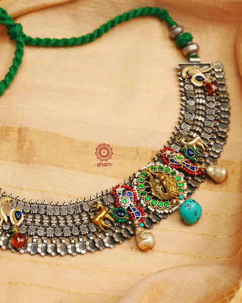 One of a kind statement wearable art pieces. An eclectic mix of elements, with a play of colours, textures, forms and workmanship. Crafted in Silver with two tones that makes this neckpiece so versatile and unique. Intricately detailed 3d peacock takes center stage in this neckpiece, two kundan peacocks on the side, with reindeers and parrots to add to the charm. Modern Heirloom pieces that can be worn across generations.
