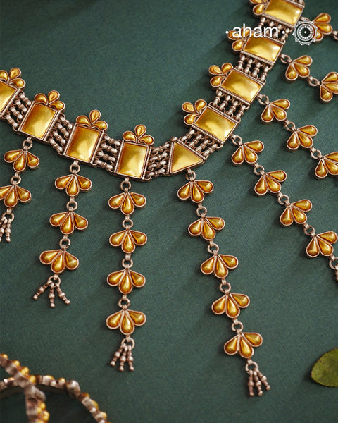 Enhance your style with the timeless elegance of the Dual Tone Silver Choker. Handcrafted by skilled karigars in Barmer, Rajasthan, this neckpiece features traditional Bandhel work, where a thin sheet of hand beaten carat gold is set on 92.5 silver using a unique wax setting technique. A classic representation of fine Indian traditional craftsmanship.