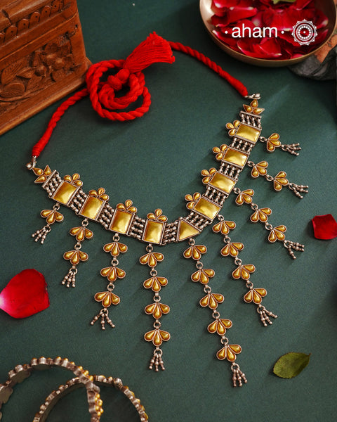 Enhance your style with the timeless elegance of the Dual Tone Silver Choker. Handcrafted by skilled karigars in Barmer, Rajasthan, this neckpiece features traditional Bandhel work, where a thin sheet of hand beaten carat gold is set on 92.5 silver using a unique wax setting technique. A classic representation of fine Indian traditional craftsmanship.