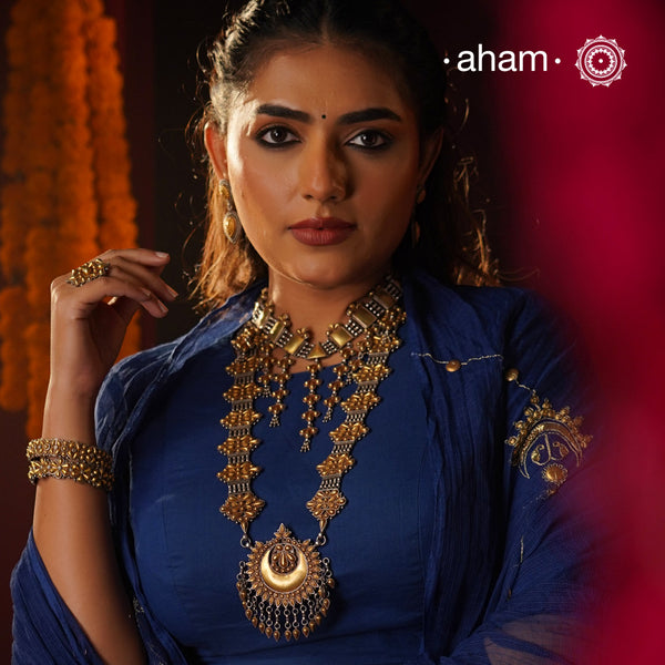 Enhance your style with the timeless elegance of the Dual Tone Silver Long Neckpiece. Handcrafted by skilled karigars in Barmer, Rajasthan, this neckpiece features traditional Bandhel work, where a thin sheet of hand beaten 22 carat gold is set on 92.5 silver using a unique wax setting technique. A classic representation of fine Indian traditional craftsmanship.